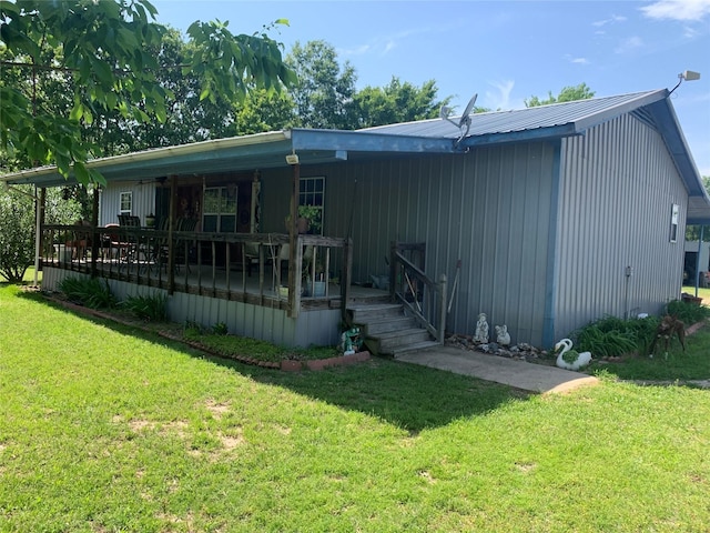 back of house featuring a yard and metal roof