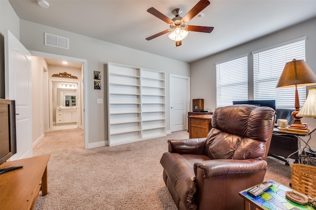 carpeted living room featuring baseboards, visible vents, and ceiling fan