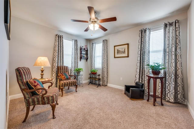 living area with carpet floors, a ceiling fan, and baseboards