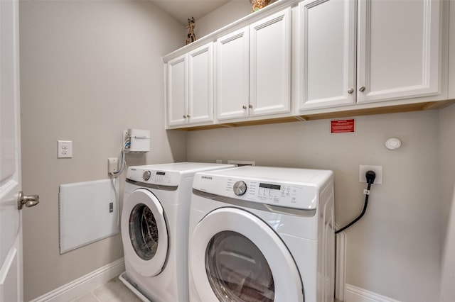 laundry area with washing machine and dryer, baseboards, and cabinet space