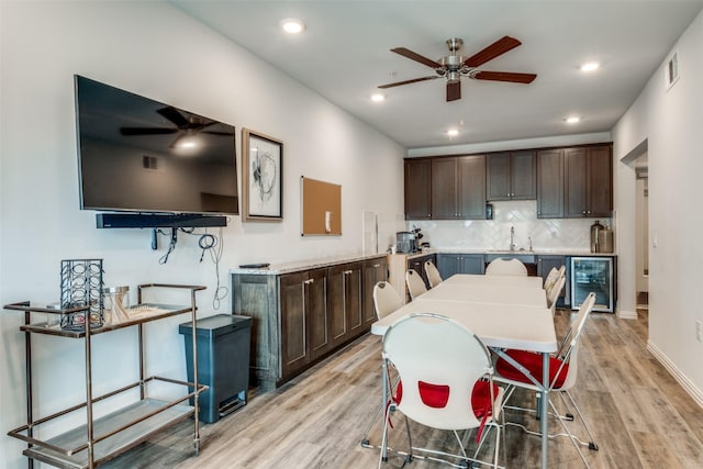 kitchen with dark brown cabinets, a ceiling fan, visible vents, and wine cooler