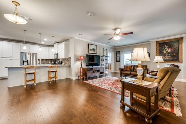 living area featuring ornamental molding, visible vents, ceiling fan, and dark wood finished floors