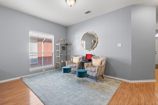 sitting room with baseboards, wood finished floors, and visible vents