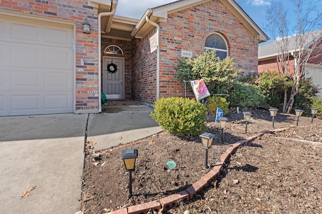 entrance to property featuring brick siding and a garage