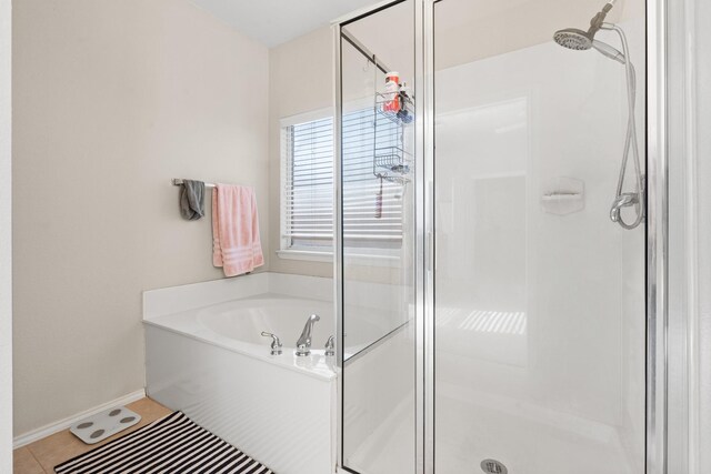 bathroom featuring a bath, baseboards, tile patterned floors, and a stall shower
