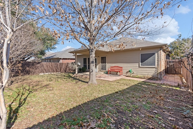 back of property featuring a lawn, a patio area, and a fenced backyard