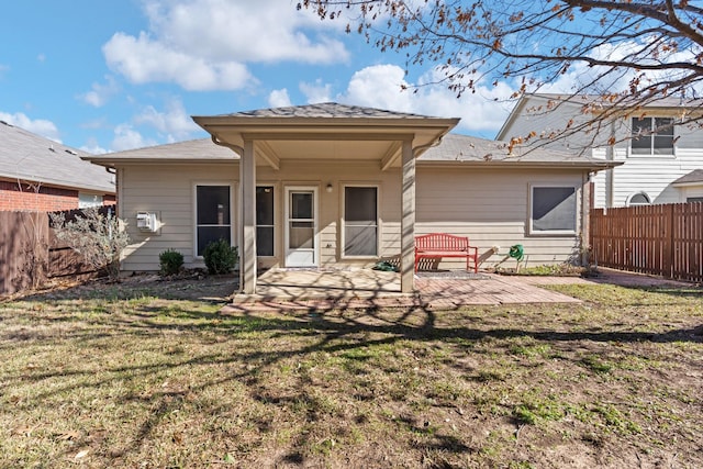 back of property featuring a lawn, a fenced backyard, and a patio