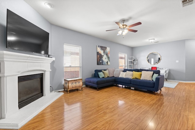 living room with a ceiling fan, light wood-style floors, visible vents, and plenty of natural light
