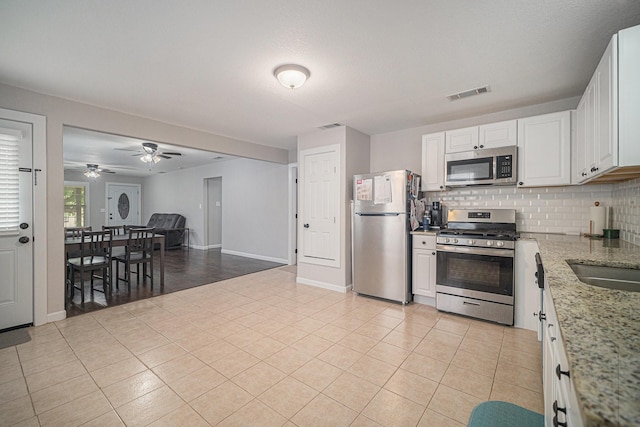 kitchen featuring appliances with stainless steel finishes, tasteful backsplash, light tile patterned flooring, and visible vents
