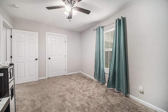 unfurnished bedroom featuring a ceiling fan, baseboards, and carpet