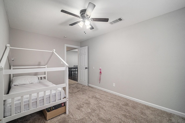 carpeted bedroom with ceiling fan, baseboards, and visible vents