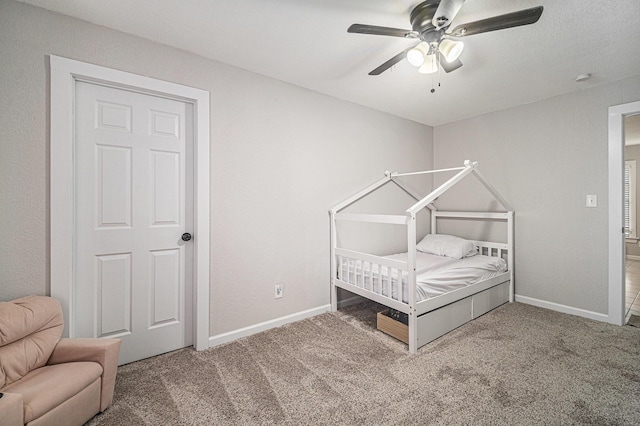 bedroom with a ceiling fan, baseboards, and carpet