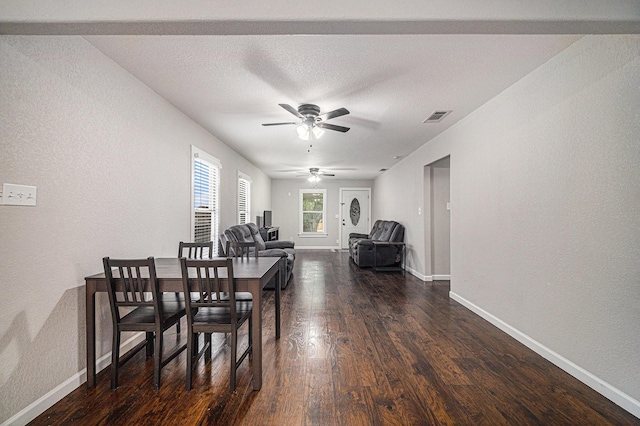 dining area with dark wood finished floors, ceiling fan, baseboards, and visible vents