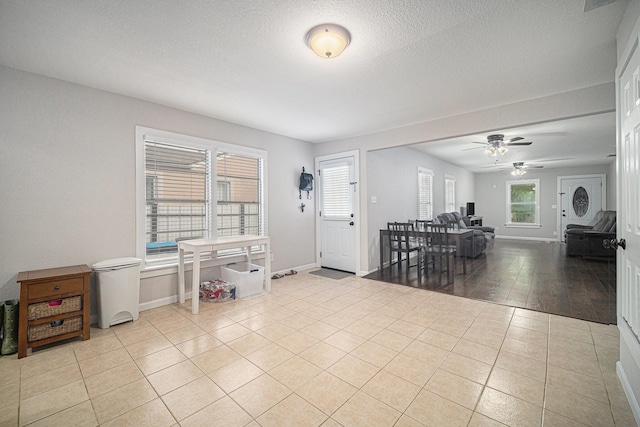 entryway featuring ceiling fan, baseboards, tile patterned floors, and a textured ceiling