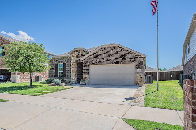 view of front of home with driveway, stone siding, an attached garage, fence, and a front yard