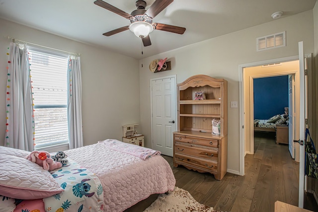 bedroom with dark wood finished floors, ceiling fan, and visible vents