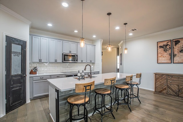 kitchen featuring stainless steel microwave, visible vents, dark wood-type flooring, and ornamental molding