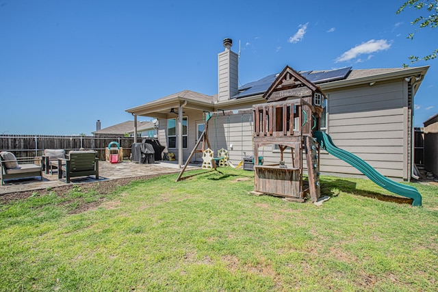 rear view of property featuring a yard, a patio area, a fenced backyard, and a playground