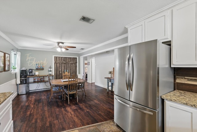 kitchen with freestanding refrigerator, a ceiling fan, visible vents, and ornamental molding