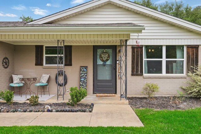 view of front of home featuring brick siding and a shingled roof