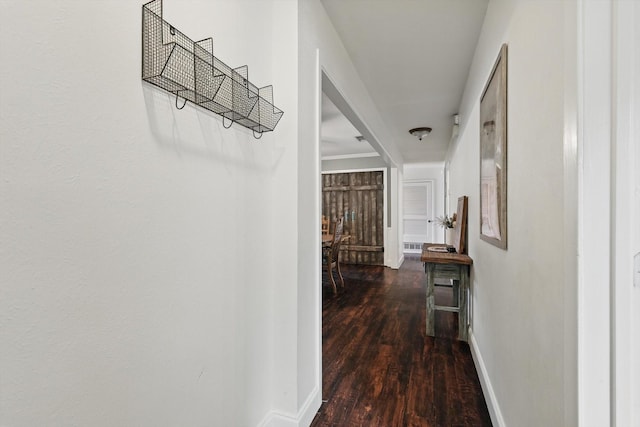 corridor featuring baseboards and wood finished floors