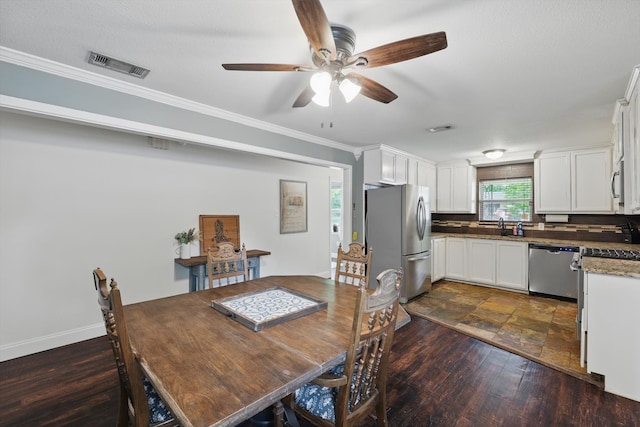 dining area featuring crown molding, baseboards, a ceiling fan, and visible vents