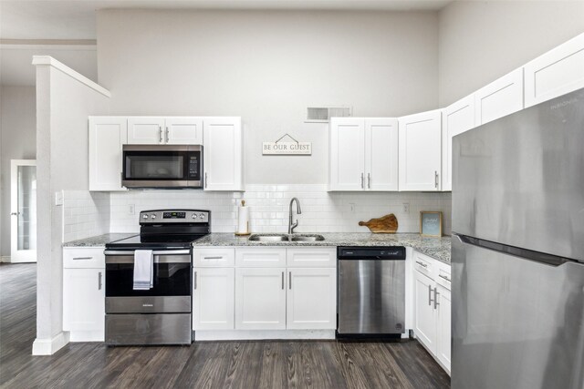 7012 Newberry Ct E, Fort Worth, TX 76120 - kitchen with a sink, stainless steel appliances, white cabinets, and dark wood finished floors