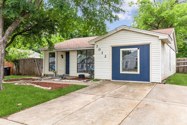 7012 Newberry Ct E, Fort Worth, TX 76120 - ranch-style house featuring a front lawn, a shingled roof, and fence