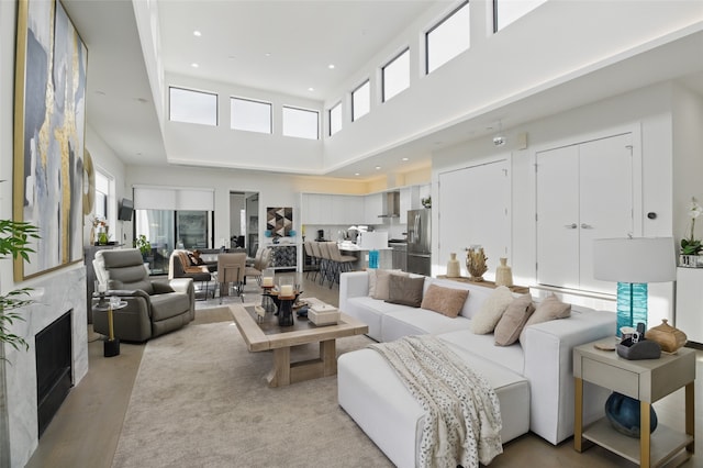 3923 Cole Ave Unit 303, Dallas, TX 75204 - living area with a high end fireplace, a wealth of natural light, a high ceiling, and light wood-type flooring