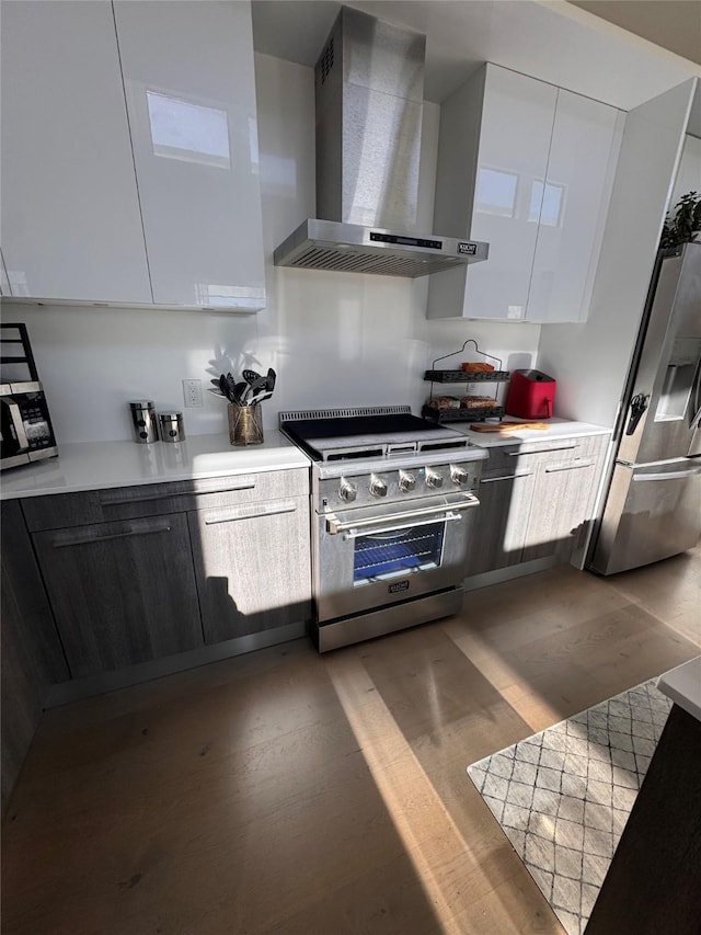 3923 Cole Ave Unit 303, Dallas, TX 75204 - kitchen featuring modern cabinets, wall chimney range hood, stainless steel appliances, and light countertops