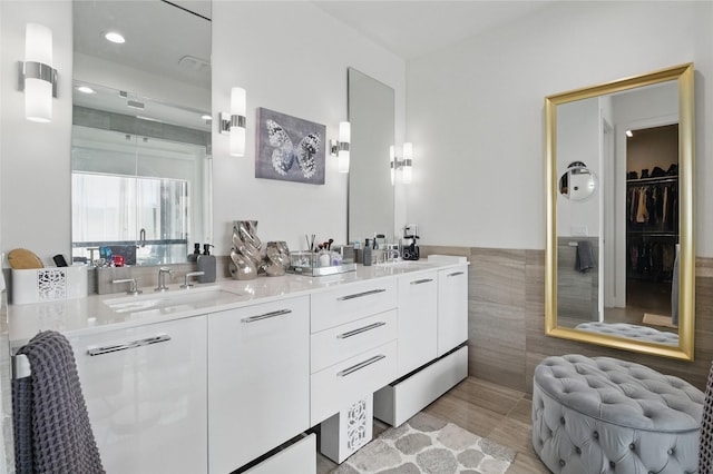 3923 Cole Ave Unit 303, Dallas, TX 75204 - full bathroom with double vanity, tile walls, and a sink