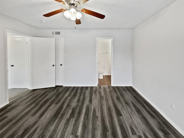 unfurnished bedroom with visible vents, baseboards, ensuite bath, and wood finished floors