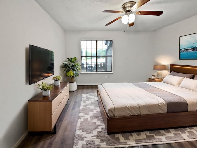 bedroom with dark wood finished floors, baseboards, and a ceiling fan