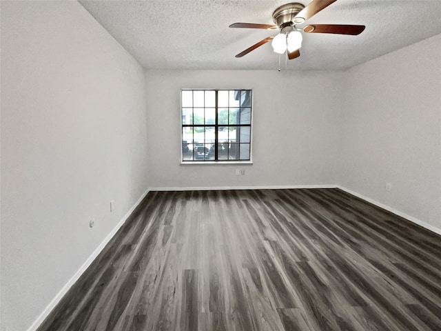 empty room featuring baseboards, a ceiling fan, a textured ceiling, and dark wood-style floors