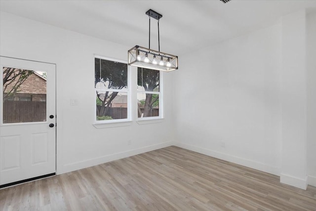 1941 Juniper Dr, Little Elm, TX 75068 - unfurnished dining area with light wood finished floors, plenty of natural light, and baseboards