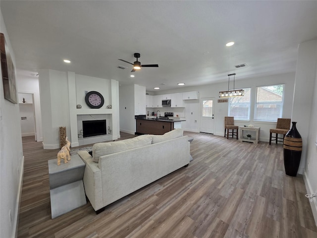 1941 Juniper Dr, Little Elm, TX 75068 - living room featuring baseboards, recessed lighting, light wood-style floors, a premium fireplace, and ceiling fan