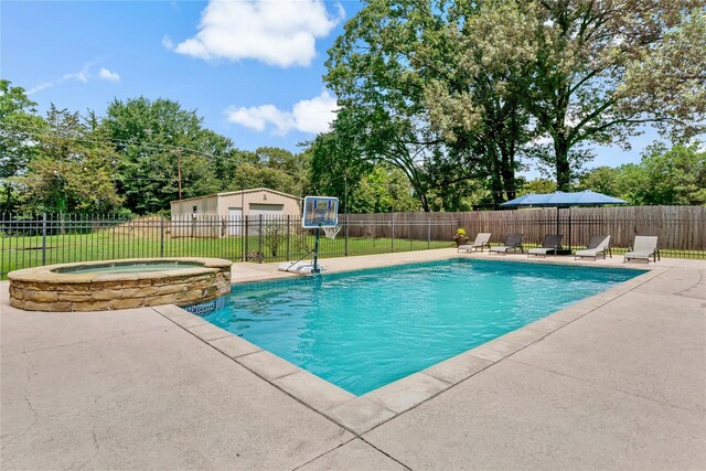 view of swimming pool with a pool with connected hot tub, a patio, and fence