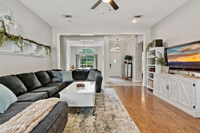 living area featuring a ceiling fan, light wood finished floors, and visible vents