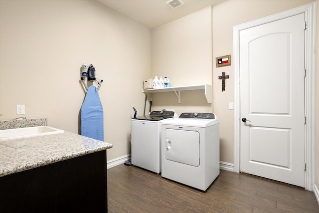 clothes washing area featuring a sink, independent washer and dryer, laundry area, and dark wood finished floors