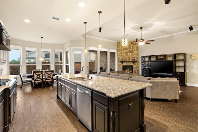 kitchen with stainless steel appliances, a stone fireplace, visible vents, a sink, and ceiling fan