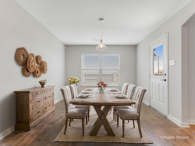 dining room featuring dark wood finished floors, baseboards, and visible vents