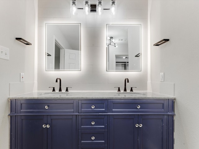 bathroom with double vanity, visible vents, and a sink