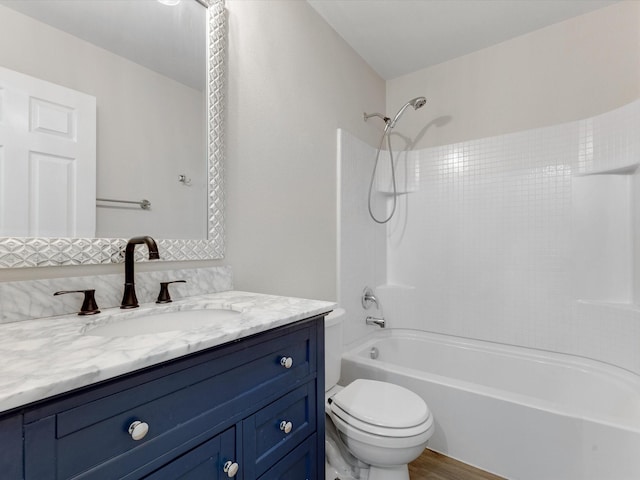 bathroom with wood finished floors, toilet, vanity, and shower / washtub combination