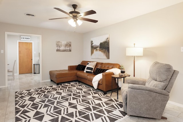 living area with visible vents, baseboards, and ceiling fan