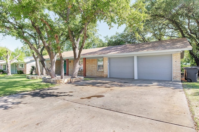 ranch-style home with concrete driveway, an attached garage, brick siding, and a front lawn