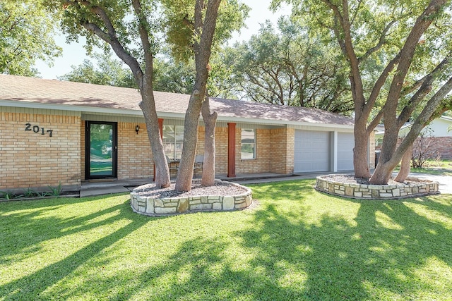 single story home featuring a porch, brick siding, a front yard, and a garage