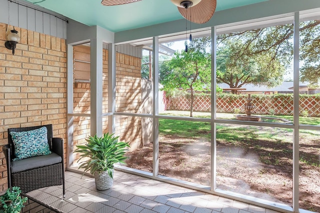 unfurnished sunroom with ceiling fan