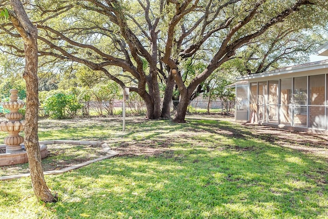 view of yard with fence and a sunroom