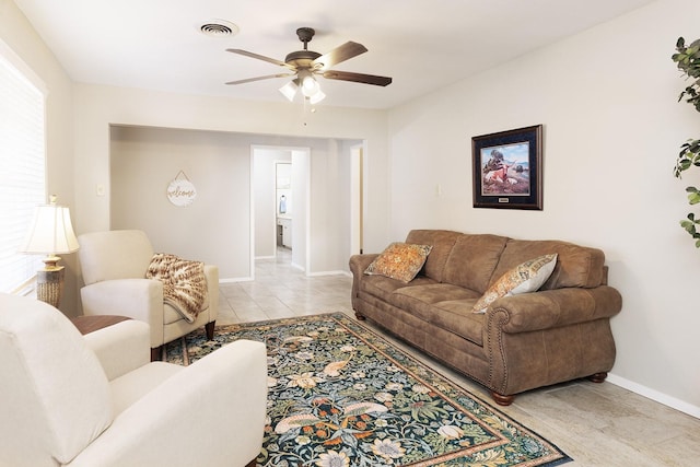 living room featuring baseboards, a ceiling fan, light tile patterned flooring, and visible vents