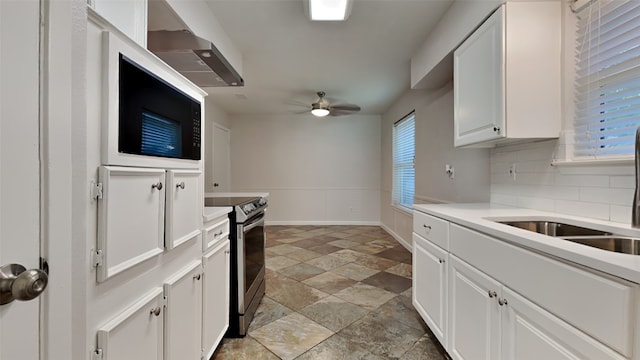 2300 Anders Dr, Mesquite, TX 75150 - kitchen featuring stainless steel electric stove, backsplash, white cabinetry, ceiling fan, and under cabinet range hood